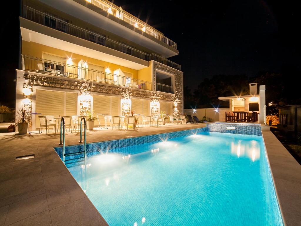 a swimming pool in front of a building at night at Sea Point Apart hotel Tivat in Tivat