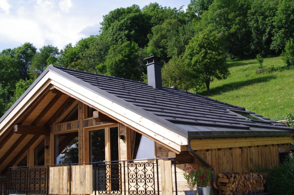 a metal roof on a house with trees in the background at Petit Chalet Vieux Bois in Bozel
