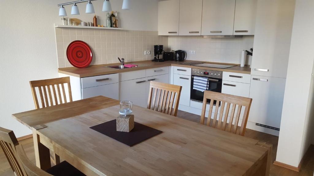 eine Küche mit einem Holztisch mit Stühlen, einem Tisch und einem Tisch in der Unterkunft Ferienwohnung Kröning in Stralsund