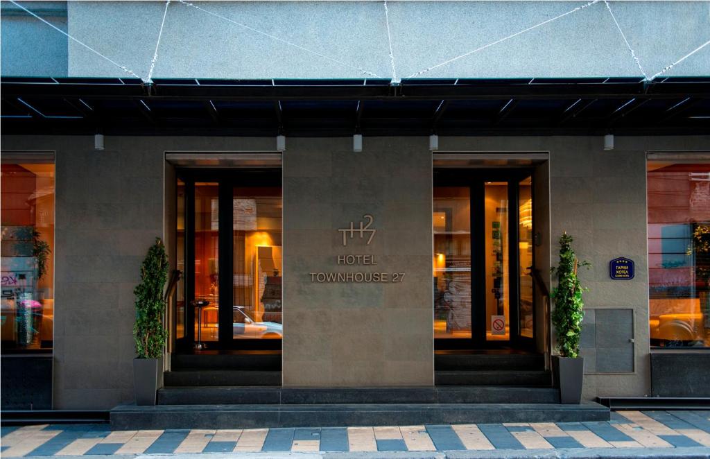 un hôtel à l'avant d'un bâtiment avec deux plantes dans l'établissement Boutique Garni Hotel Townhouse 27, à Belgrade