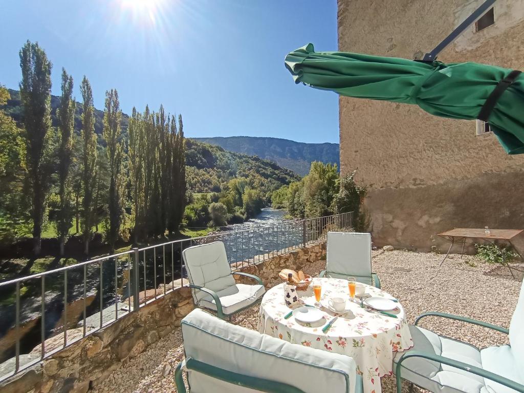 a table and chairs on a balcony with a view of a river at casa sobre rio Noguera Pallaresa in Gerri