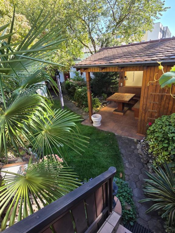 a garden with a bench and a wooden pavilion at Garten EG Wohnung mit 3 Schlafzimmern 95qm in Karlsfeld