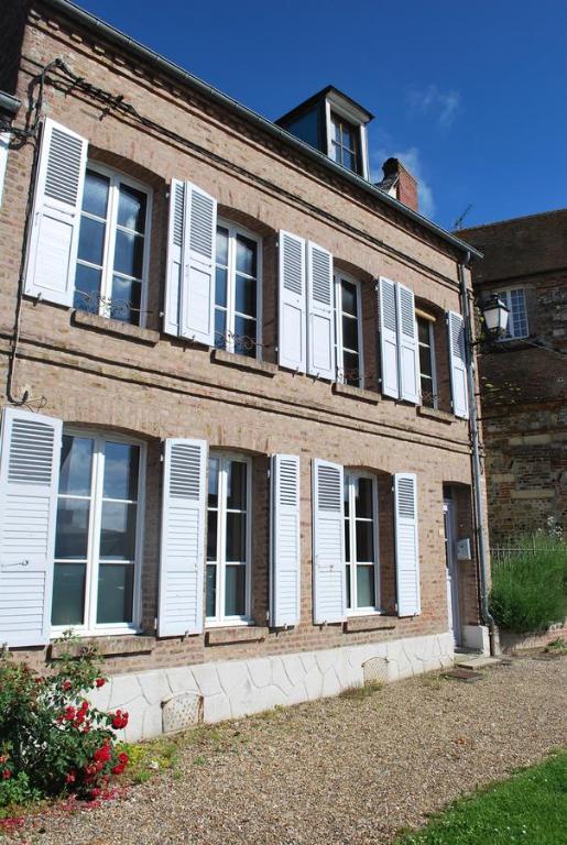 サン・ヴァレリー・シュル・ソンムにあるMaisonnette à Saint Valéry Sur Sommeの白い窓とシャッターのある古いレンガ造りの建物