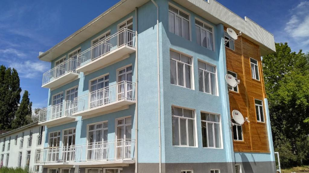 un edificio azul y blanco con balcones blancos en Guest House Parus en Bosteri