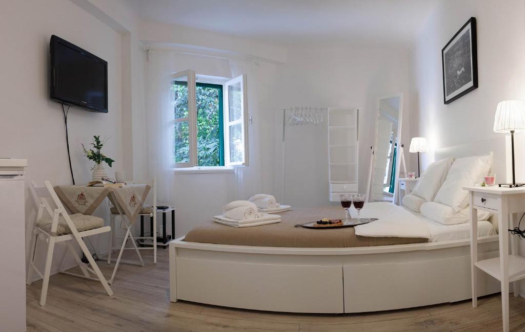 a white room with a couch and a table and chairs at Apartment Marinis in Split