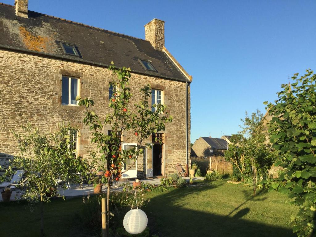 una vecchia casa di mattoni con un albero in cortile di L'ancien Presbytère d'Ardevon ad Ardevon