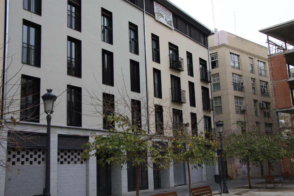 un edificio blanco con ventanas negras y luz de la calle en Apartamentos Hiedra y Tapinería Mercado Central, en Valencia