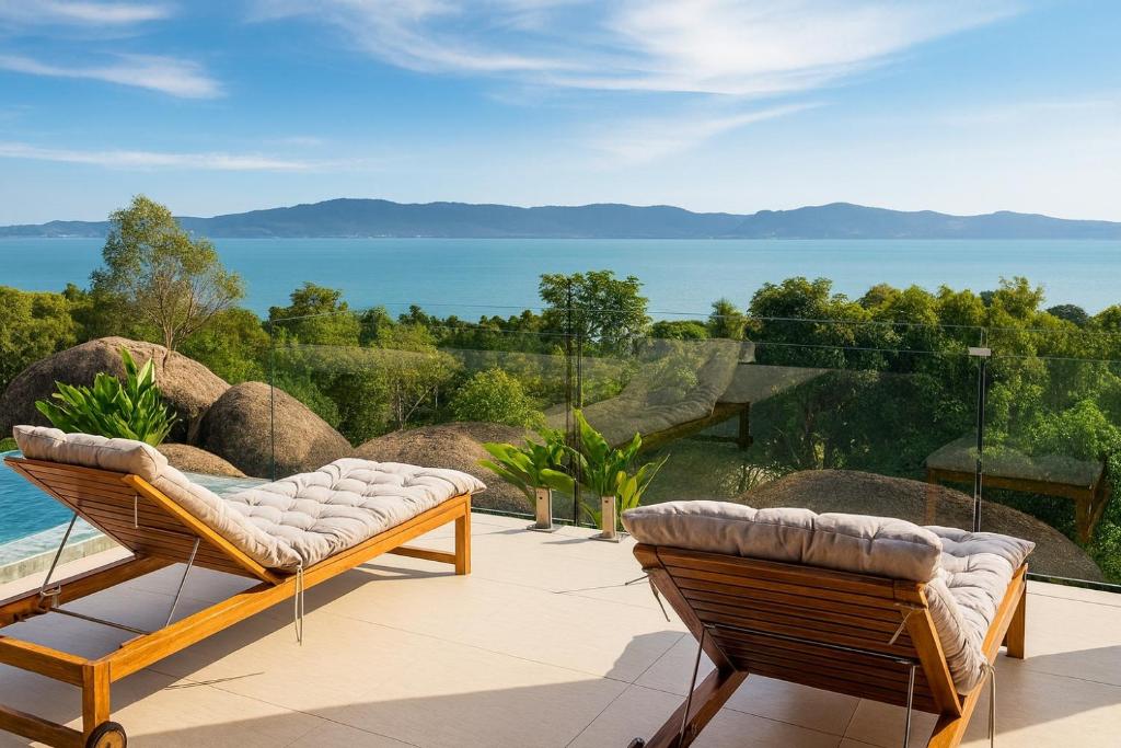 un patio con 2 sillas y vistas al agua en Villa Sabanya Sea View, en Ban Nua