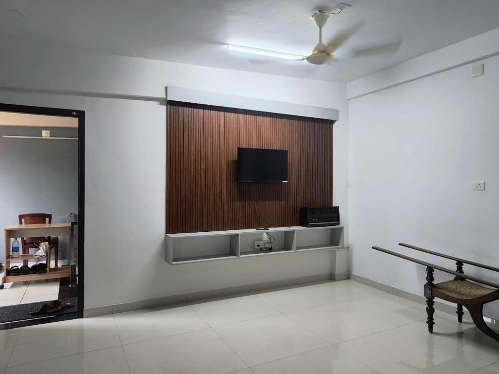 a room with a flat screen tv on a wall at Harmony Residence in Trivandrum