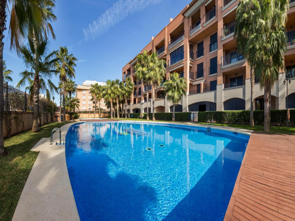 a large blue swimming pool in front of a building at Vilamar VyB in Denia