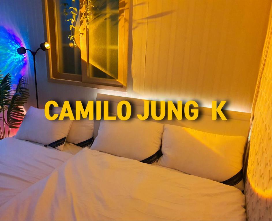 釜山にあるCamilojung K 부산역KTX 넷플릭스 셀프체크인 와이파이 12시체크아웃 지하철역の寝室に「enna juing k」と書かれたネオンサイン