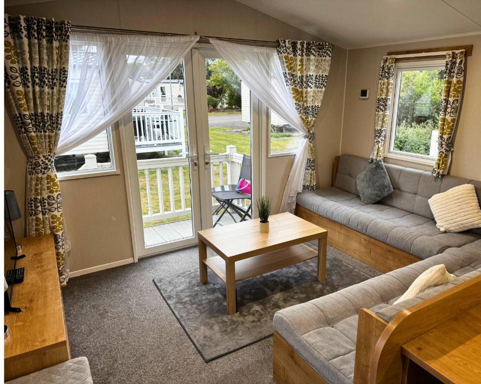 a living room with a couch and a table at 59 the cedarS in Winthorpe