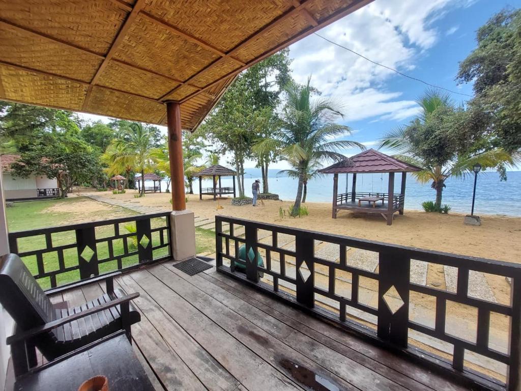 a wooden deck with a view of the beach at Siuri Cottages & Restaurant in Tokaimbu