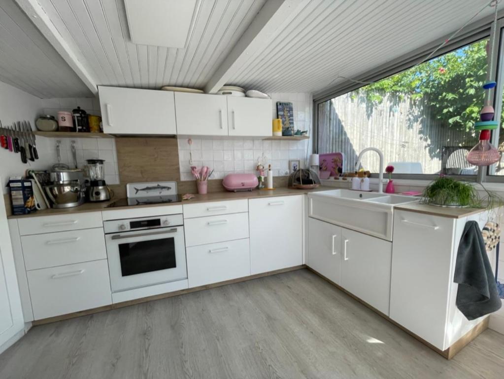 cocina con electrodomésticos blancos y ventana grande en mon petit bouchon, en Arzon