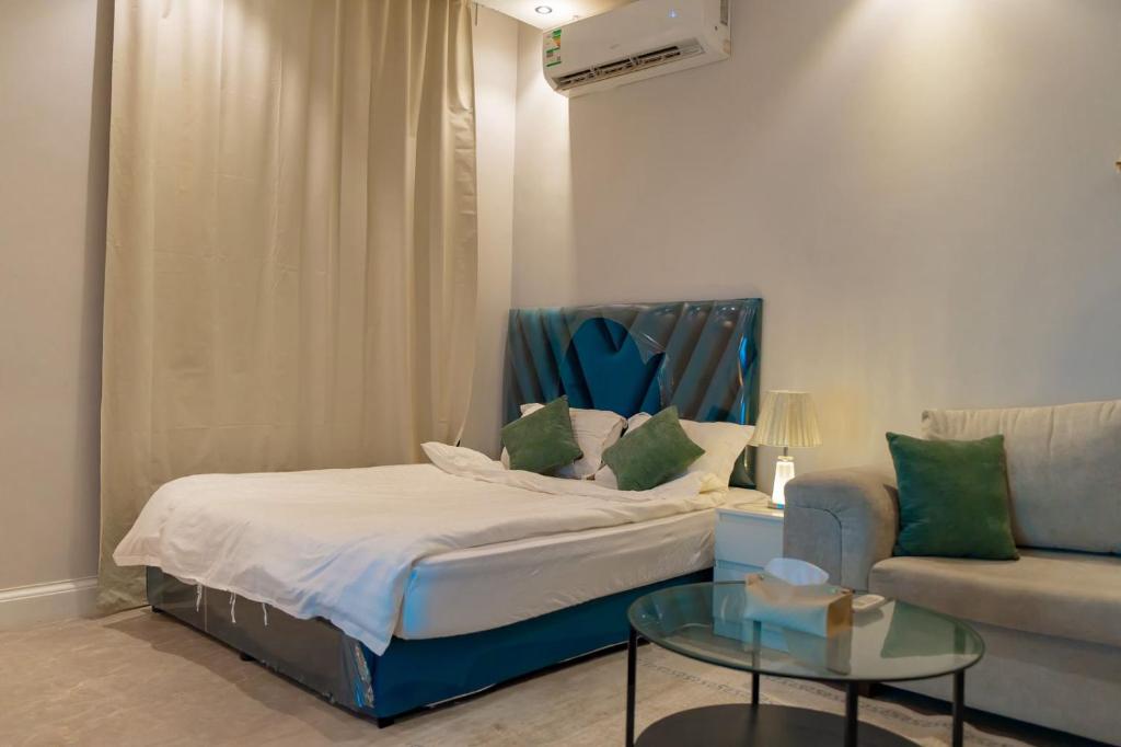 a bedroom with a bed and a couch and a table at الكهوف النجدية السليمانية in Riyadh