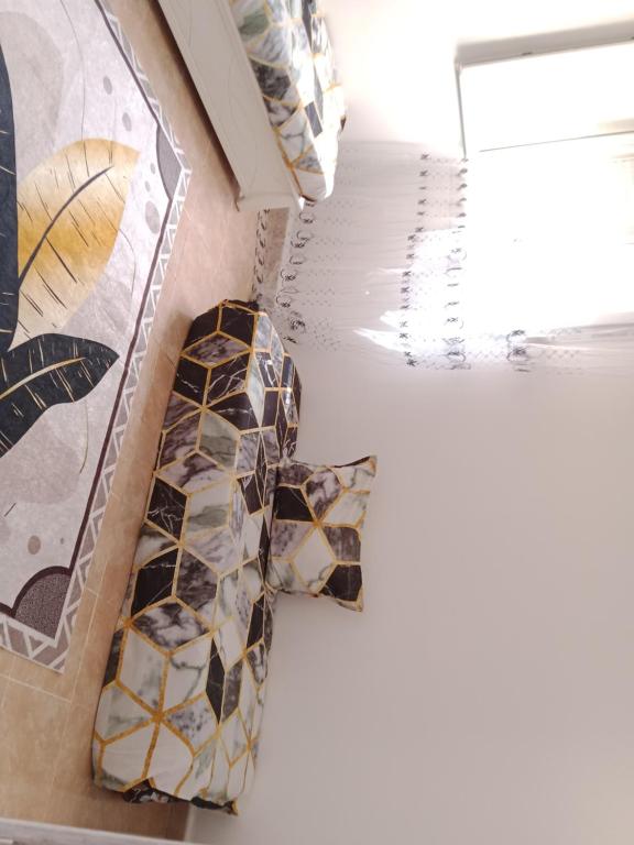 a bathroom with mosaics on the floor and a window at حمودي شقق مجهزة للكراء مرحبا بالجميع in Skikda