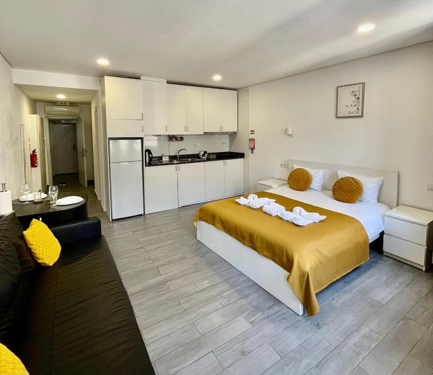 Un dormitorio con una cama grande y una cocina. en Almada Downtown 201, en Oporto