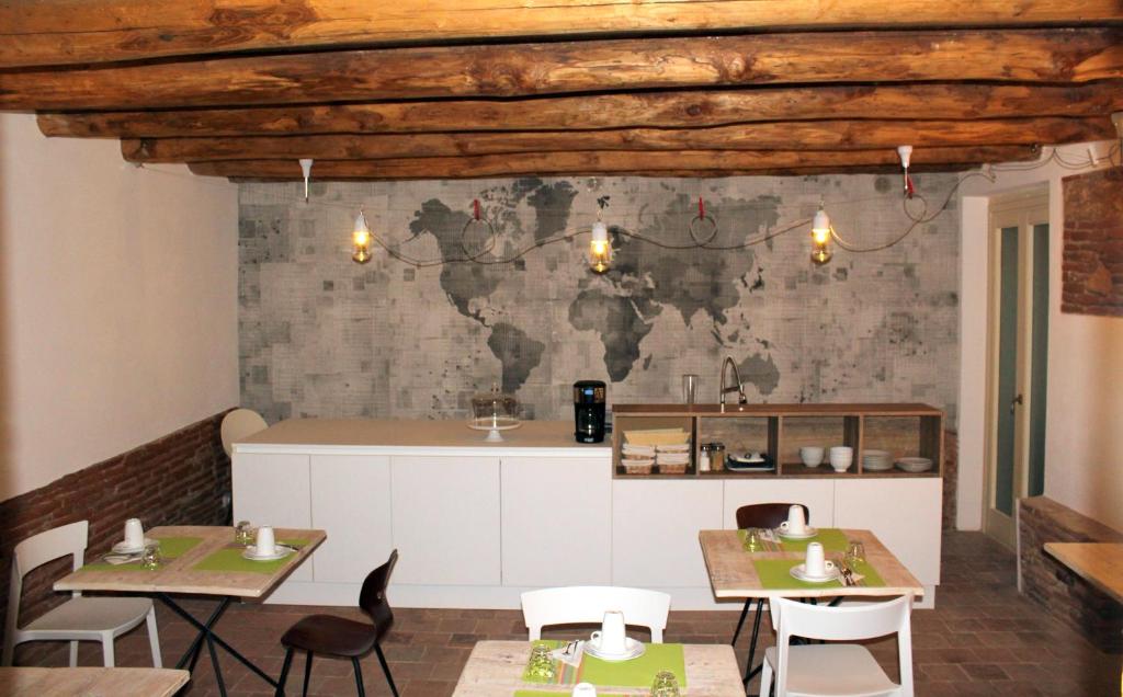 a restaurant with tables and chairs and a kitchen at Eleonora Room & Breakfast in Oristano