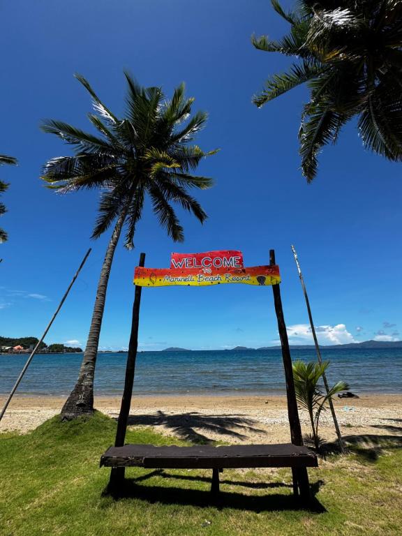 un'altalena su una spiaggia con palme e l'oceano di Marinelli Beach Resort a San Agustin