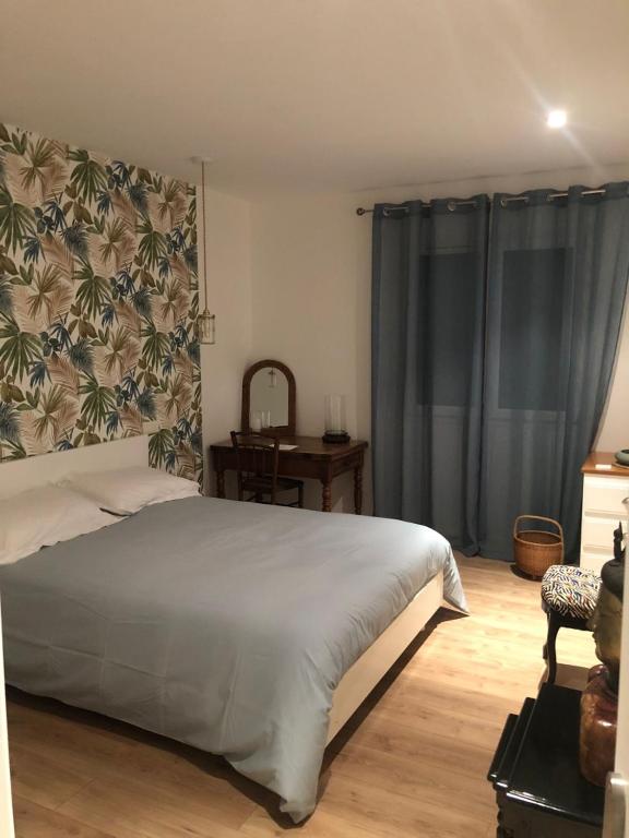 a bedroom with a bed and a table and a window at Chambre 2 personnes in Saint-André-de-Sangonis