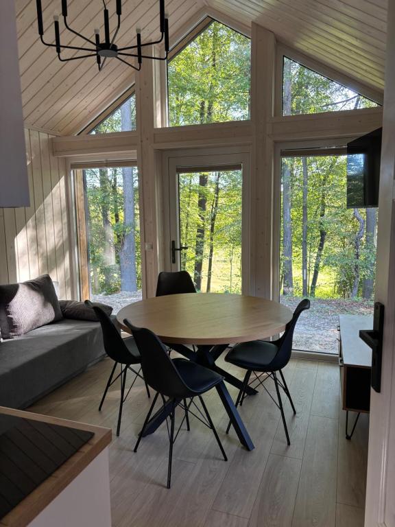 a living room with a wooden table and chairs at Domki nad Krzyworzeką in Dobczyce