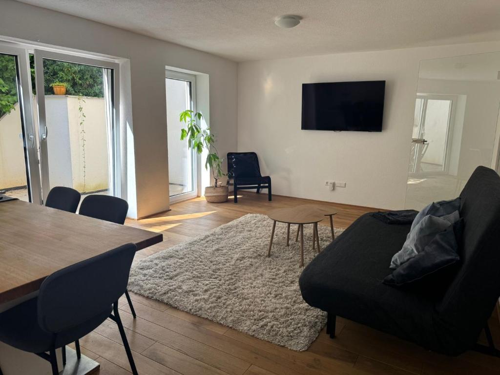 a living room with a black couch and a table at Großzügiges Apartment in Biberach an der Riss in Biberach an der Riß