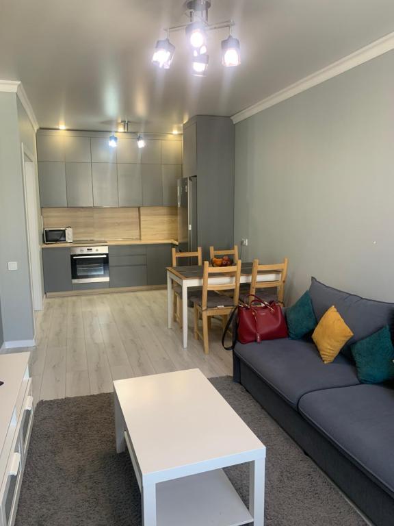a living room with a couch and a table at Толеби in Astana