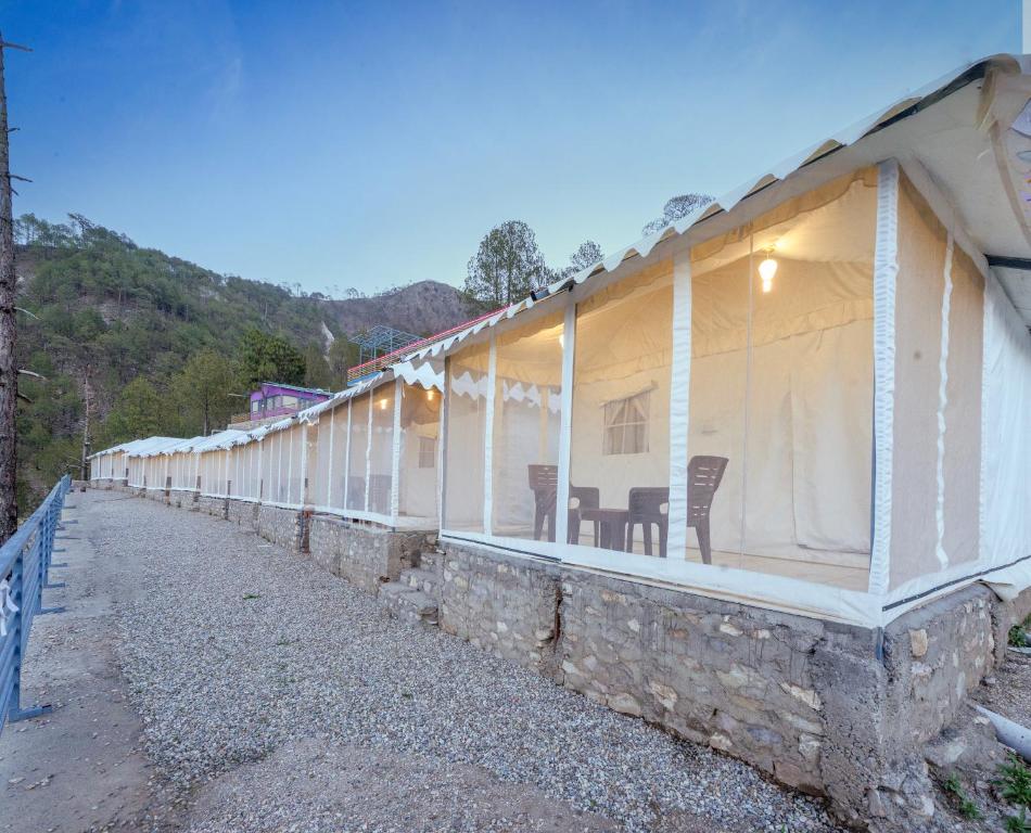 eine lange Reihe weißer Gebäude mit Stühlen darauf in der Unterkunft Orophile Retreat Resort in Tota Ām