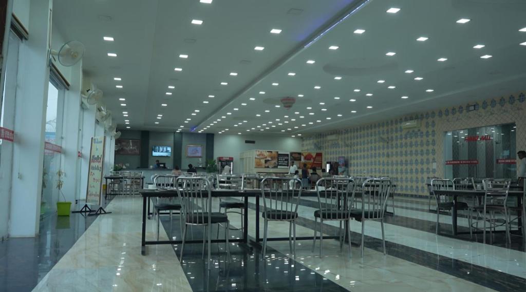 a room with tables and chairs in a mall at Hotel Holiday Fun Resort in Prāgpura