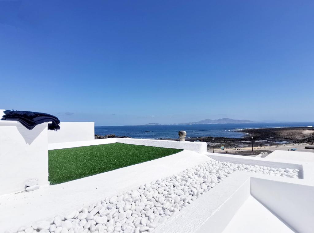 een wit huis met een groen gazon op het dak bij Sun & Beach 9 in Corralejo
