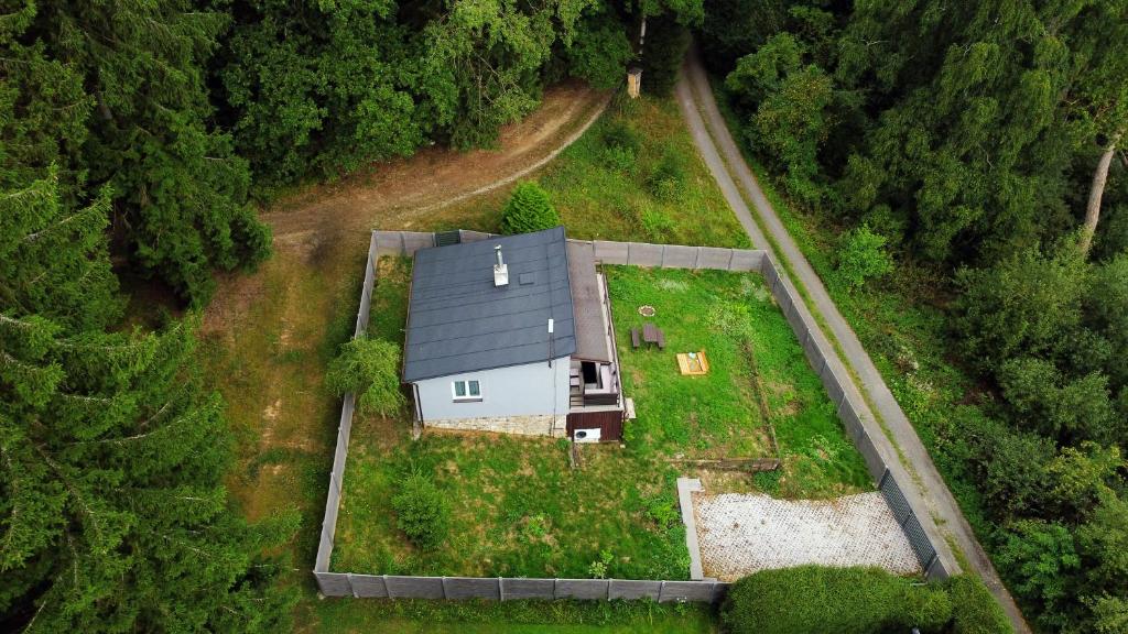 an aerial view of a house in the middle of a forest at Chata se saunou přímo u lesa, nedaleko Hracholuské přehrady 