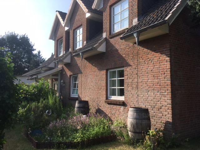 une maison en briques avec deux grands barils devant elle dans l'établissement Modernisierte Ferienwohnung Mit Balkon, à Schuby