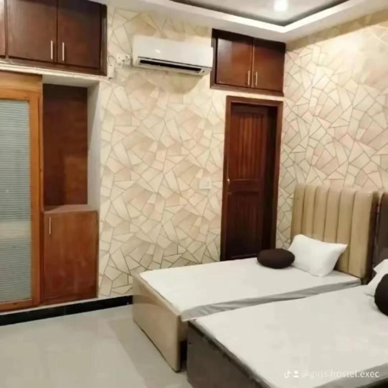 una habitación con dos camas y una pared en Girls hostel Executive Karachi defence view, en Karachi