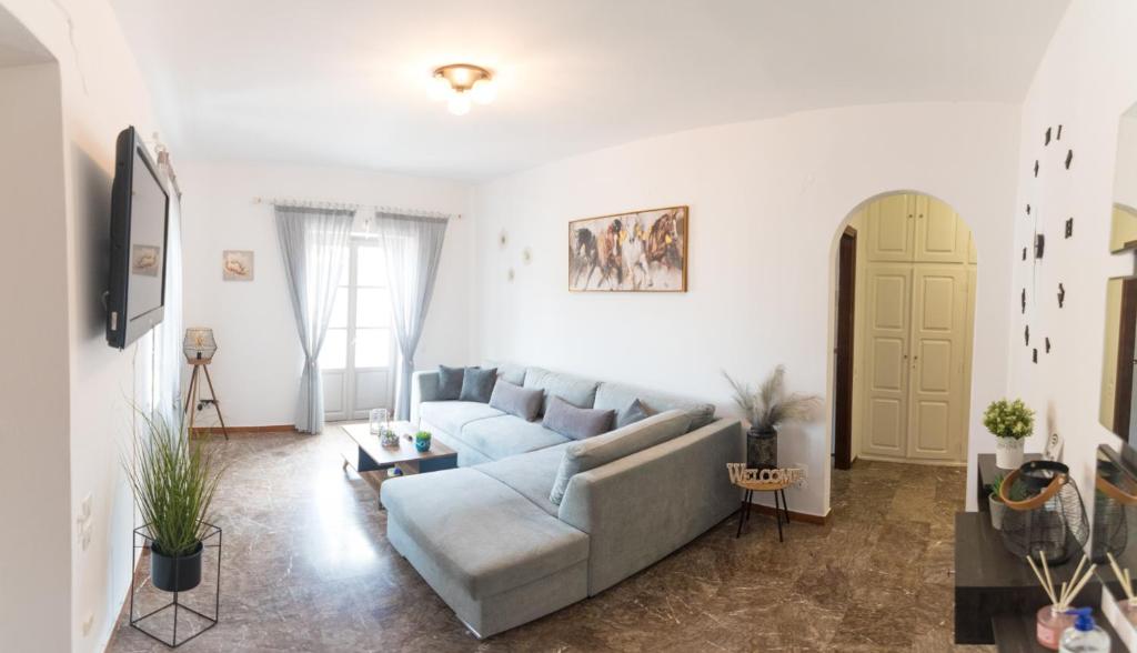 un soggiorno con un divano e un tavolo di 270° a Hydra