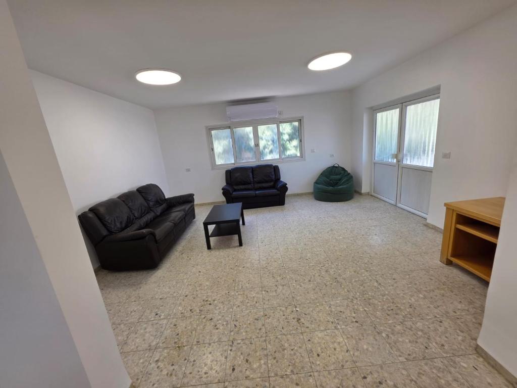 a living room with two couches and a table at Villa Gefen in Qiryat Shemona