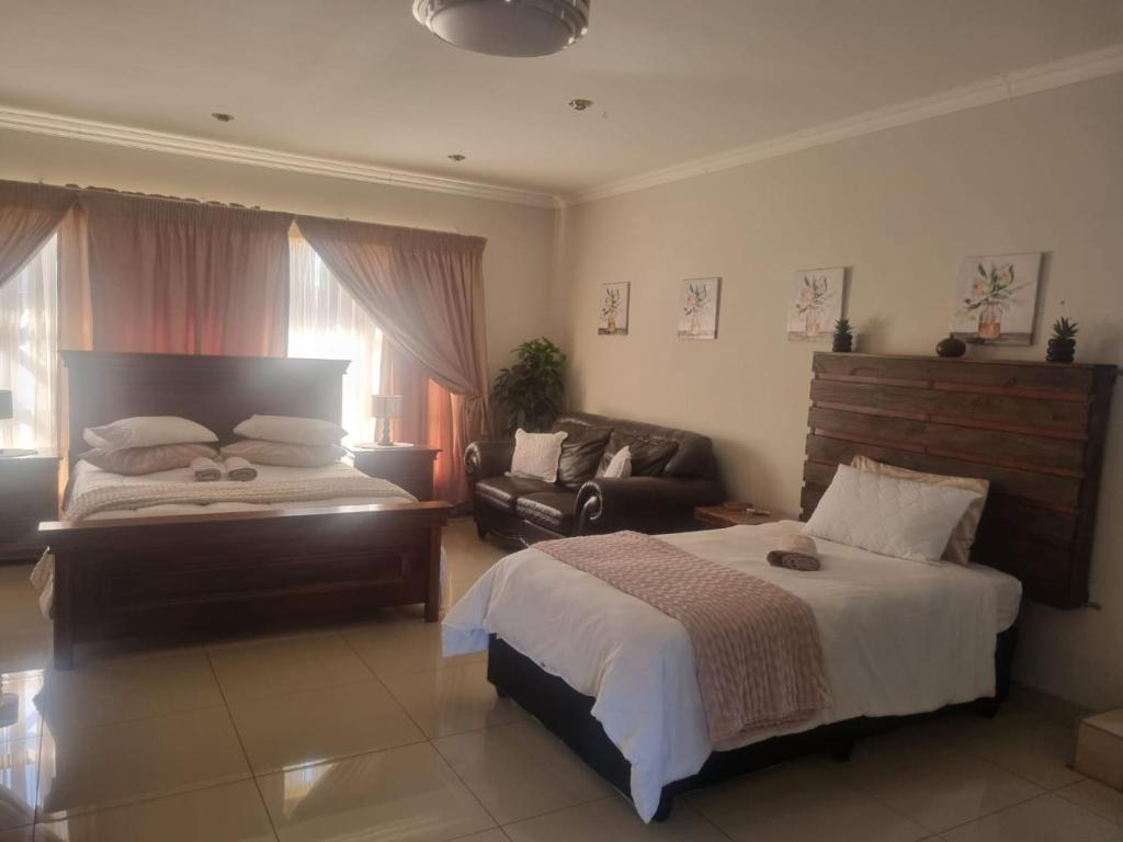 Jan KempdorpにあるVilla Caramia Guest Lodgeの大きなベッドとソファのある寝室