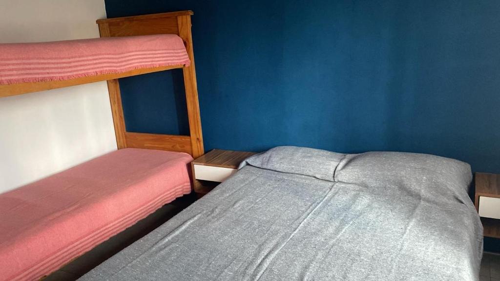 una camera con due letti a castello e una parete blu di Cabaña Carmanqui ad Alpa Corral