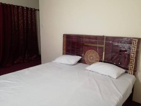 DargaiにあるGlobal Inn Guest Houseのベッドルーム1室(白いベッド2台、窓付)