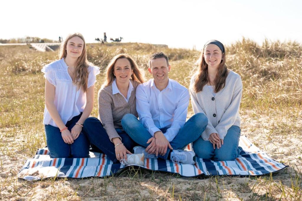 eine Gruppe von Menschen sitzt auf einer Decke am Strand in der Unterkunft Gästehaus Janßen in Cuxhaven