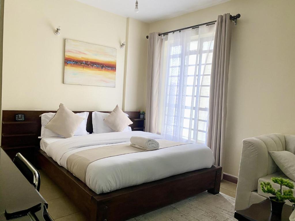 una camera da letto con un letto grande con una finestra di Apartment in Nairobi West a Nairobi