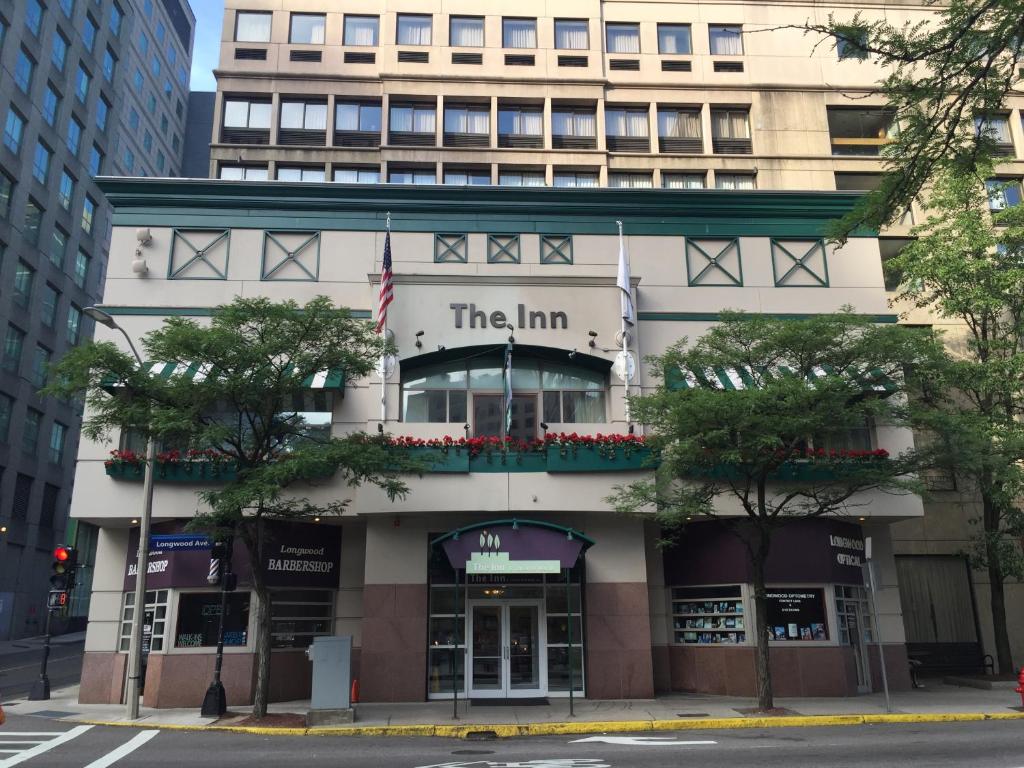 un edificio blanco alto con un cartel que lee la posada en The Inn at Longwood Medical, en Boston