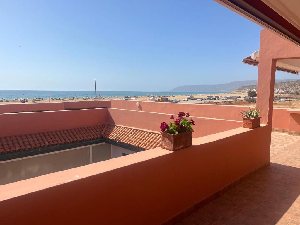 a balcony with two potted plants on a roof at Imi Beach House in Agadir nʼ Aït Sa