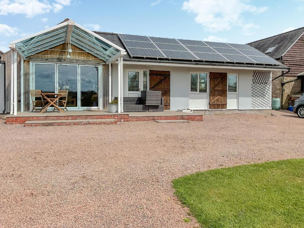 a house with solar panels on the roof at Poplars Cottage in Usk