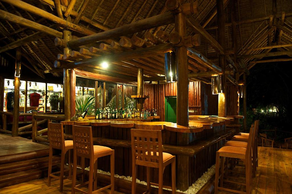 eine Bar in einem Restaurant mit Stühlen und Flaschen in der Unterkunft Samburu Intrepids Tented Camp in Archers Post