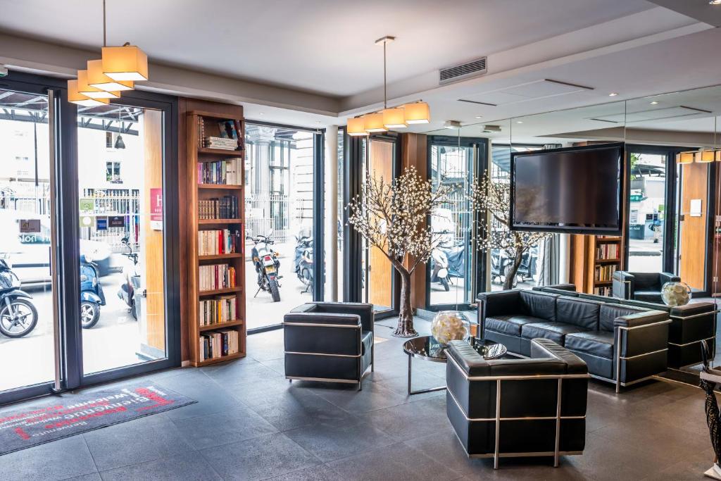 a living room with a couch and a tv at Art Hotel Eiffel in Paris