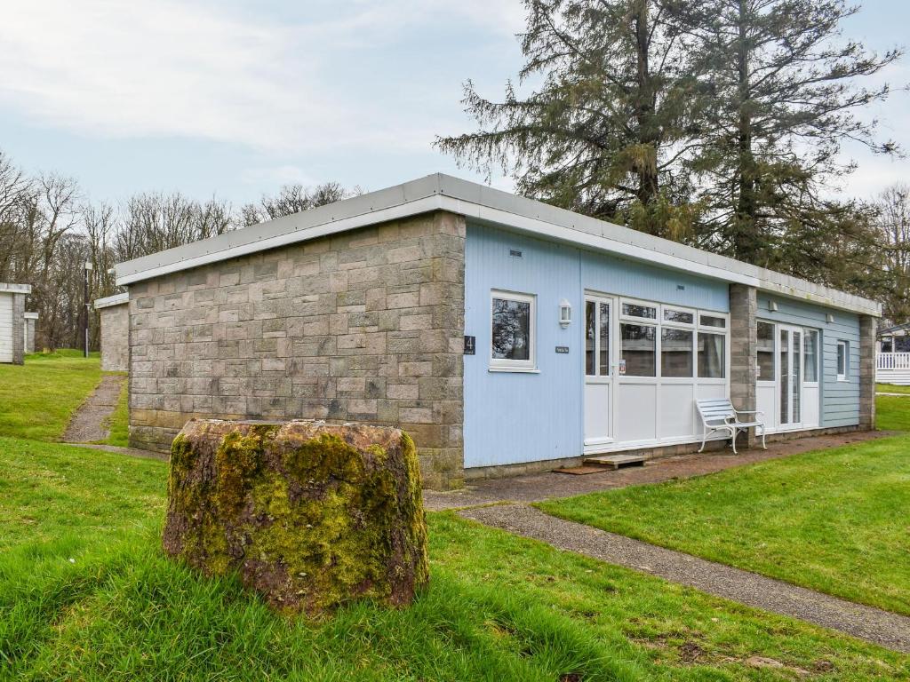 a small blue building in a grass field at Sea La Vie in Bideford