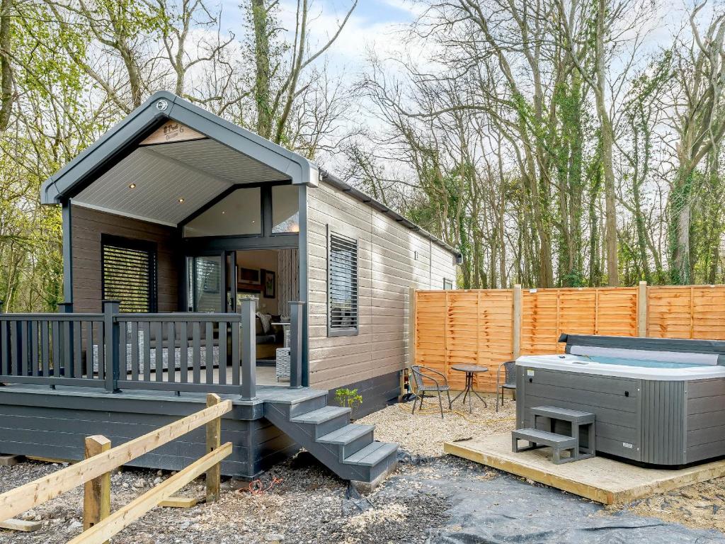 a tiny house with a hot tub and a patio at Woodpecker Lodge-Ukc5156 in Shootend
