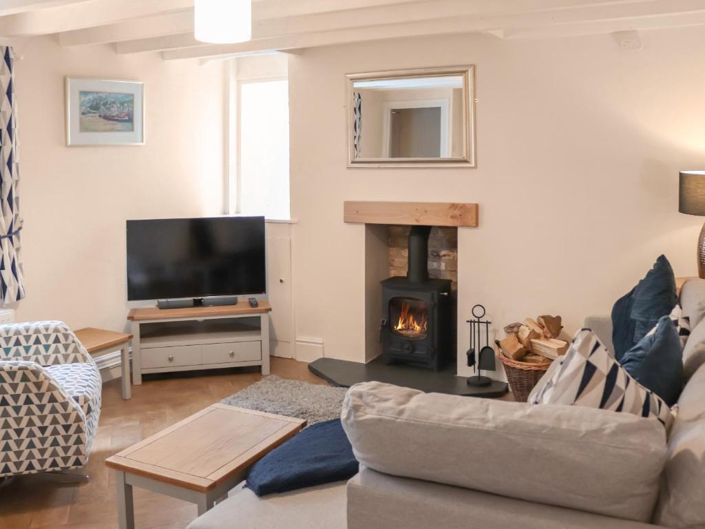 a living room with a couch and a fire place at Ty Llewelyn in Conwy