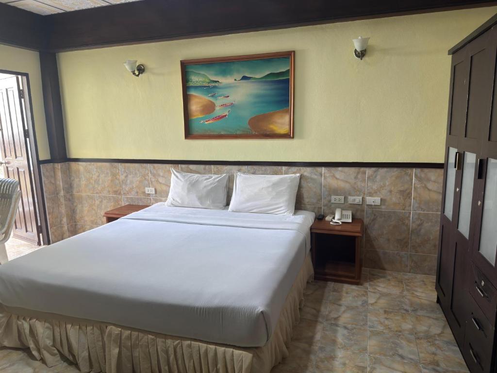 a bedroom with a large white bed and a table at Kata Palace Phuket Hotel in Kata Beach