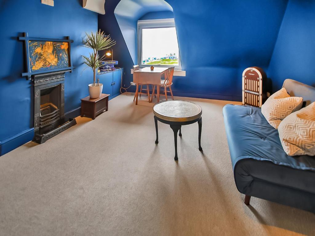a blue living room with a couch and a table at Sea View in Hollington